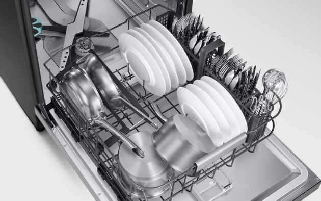 The interior of the 2025 BESPOKE AI Dishwasher with various dishes and cookware neatly arranged. The lower basket holds pots, pans, and plates, while the right section organizes knives, forks, spoons, and other kitchen utensils.